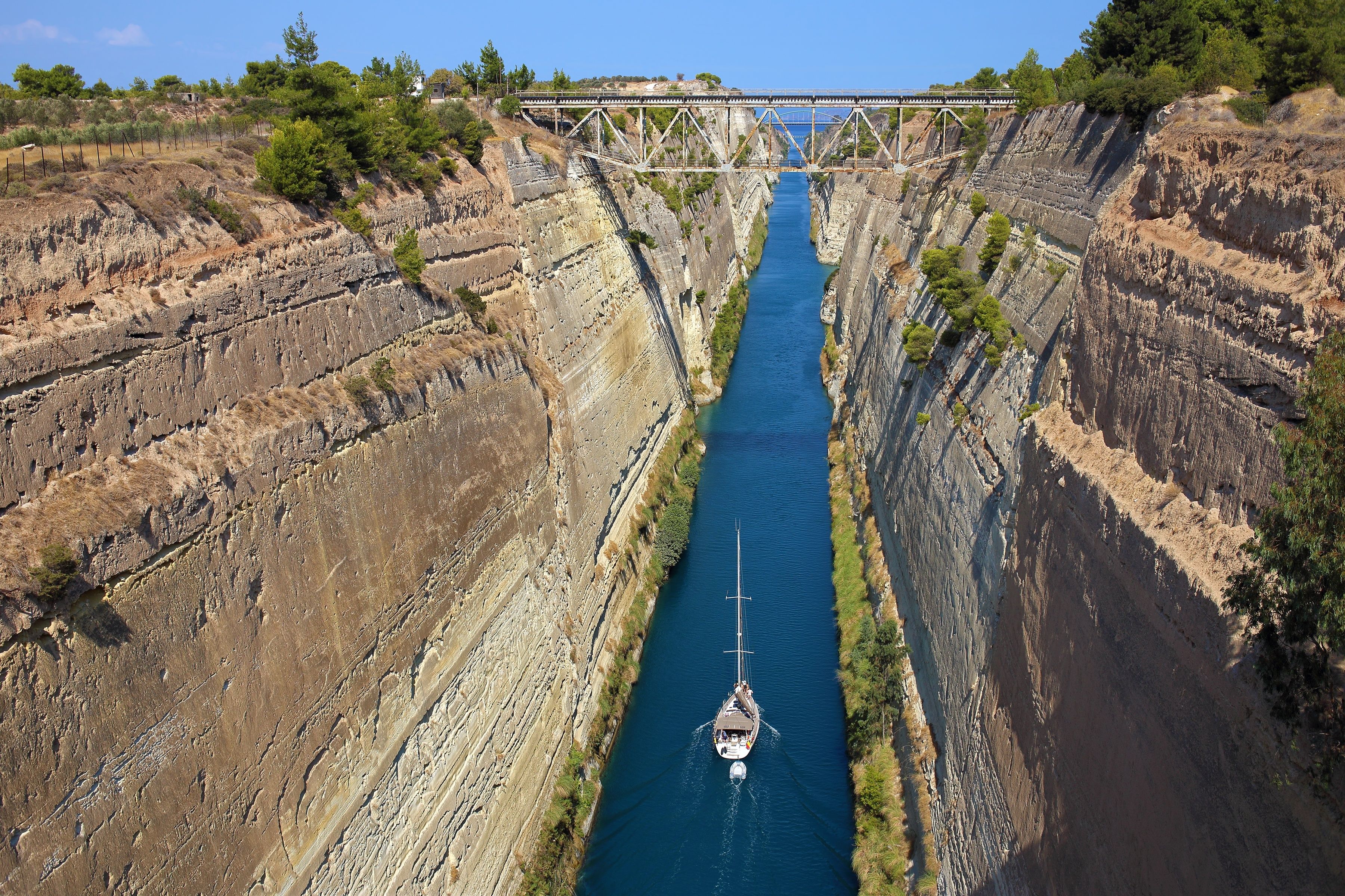 A narrow canyon with steep cliffs and a boat navigating through the water.