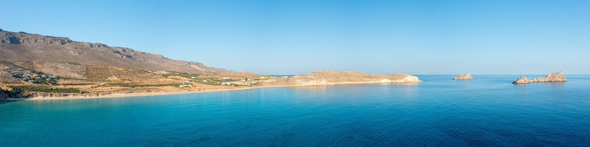 The sandy beach of Ambelou at the foot of the mountains , in Europe, Greece, Crete, towards Zakros, By the Mediterranean Sea, in summer, on a sunny day.