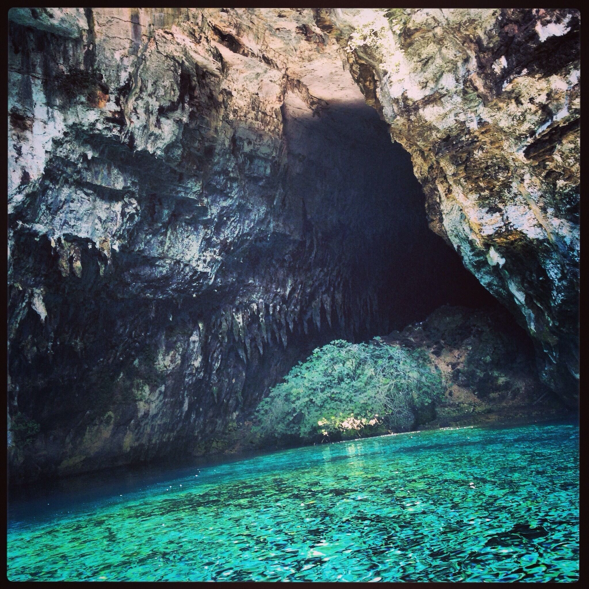Melissani Cave, Kefalonja, Greece. The water a mixture of sea water and sweet water (brackish). Tour this 'B' shaped cave by rowing boat with the sun glistening on the crystal clear, cold water. 