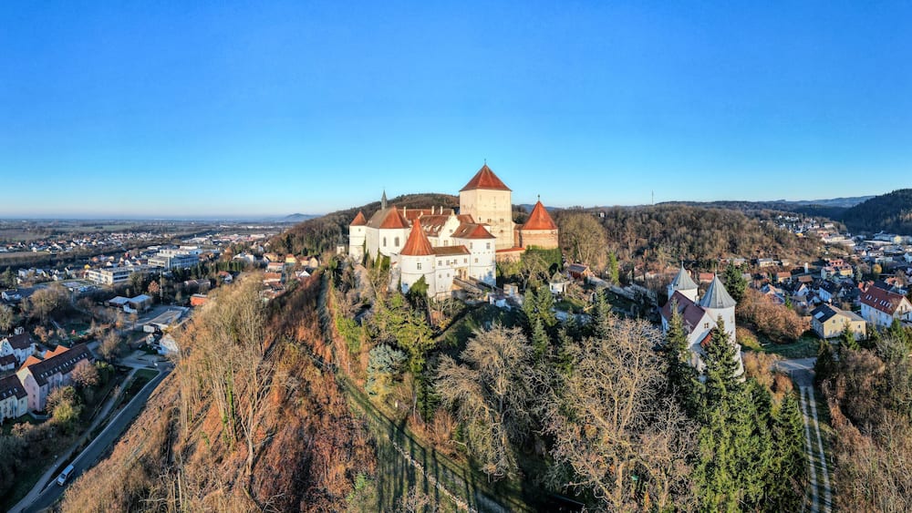 A castle on a hill overlooking a town.