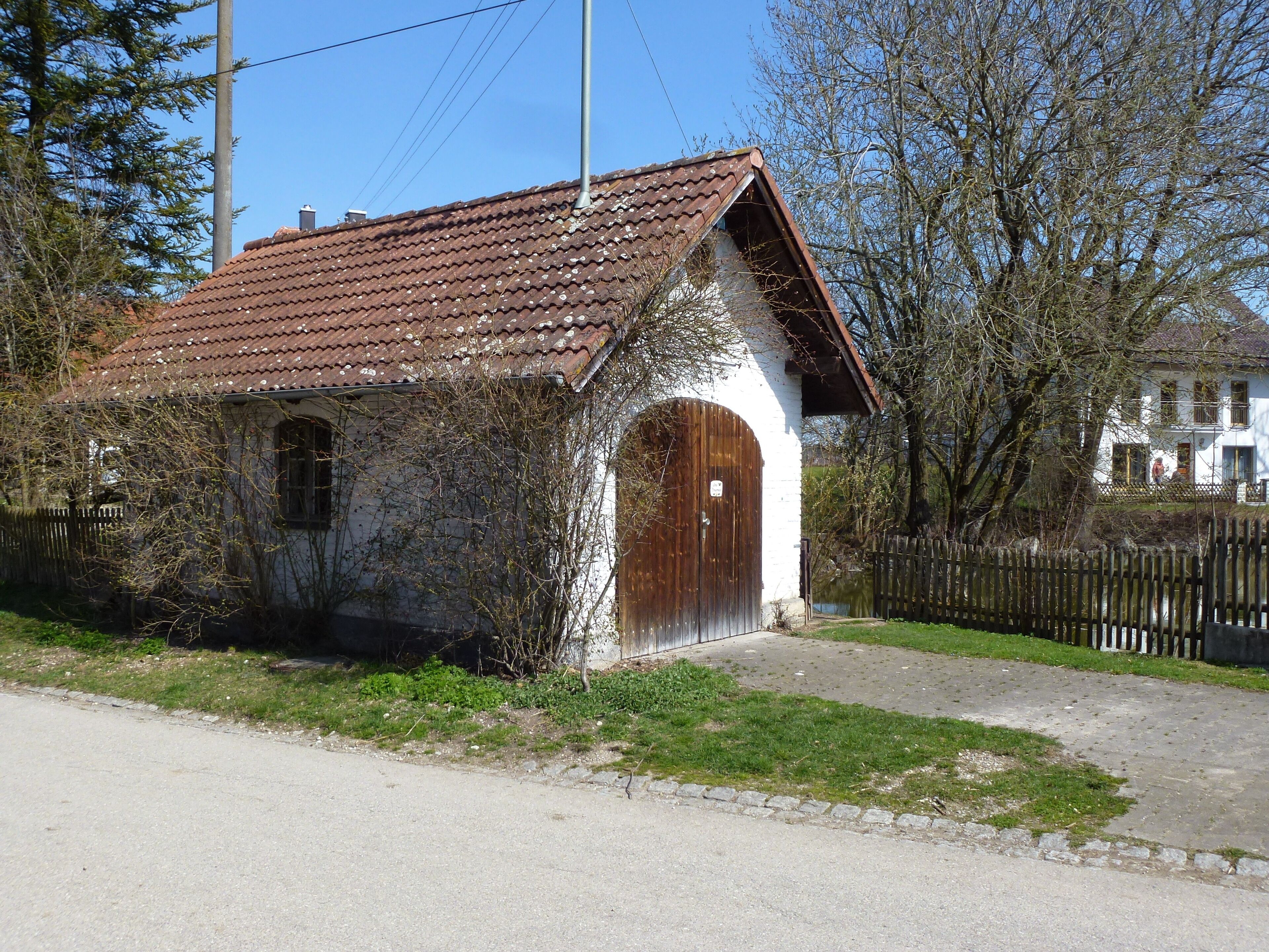 Schöffelding, Schwabhauser Straße. Neben einem kleinen Löschteich liegt das Feuerhaus