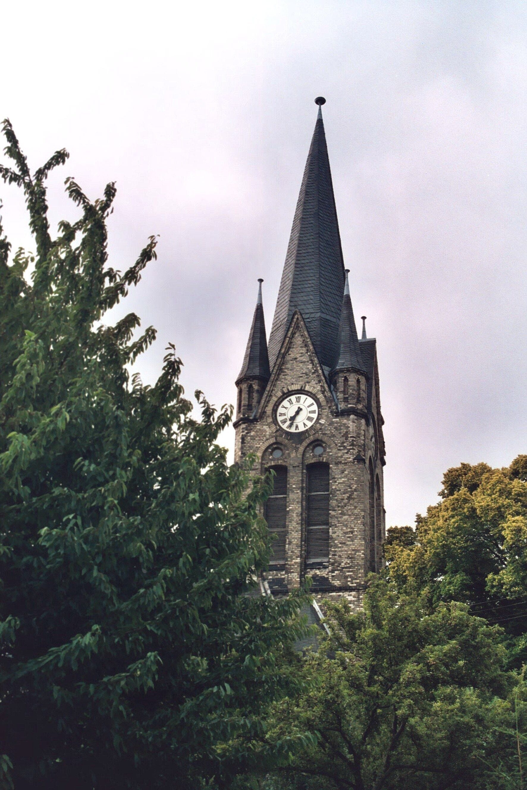 A church with a tall steeple and a clock.