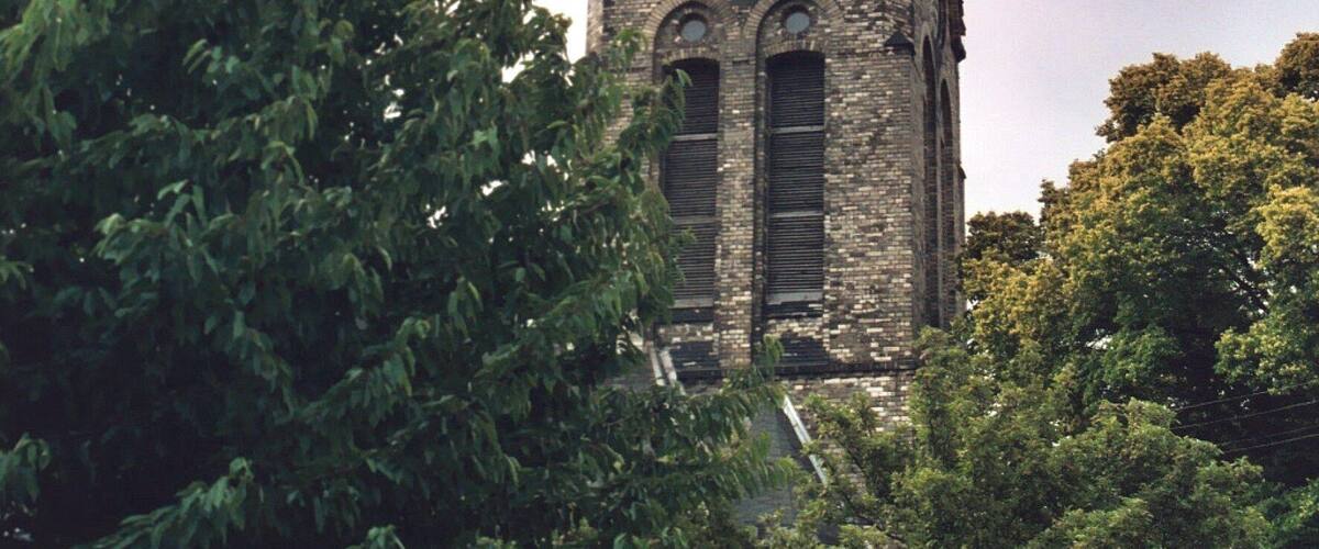 A church with a tall steeple and a clock.