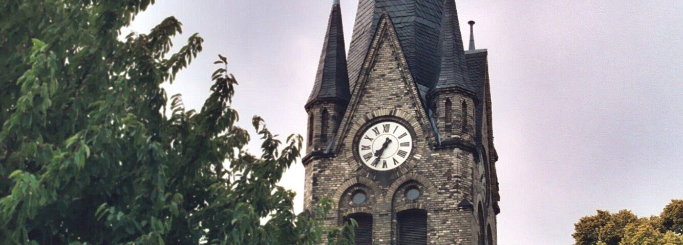 A church with a tall steeple and a clock.