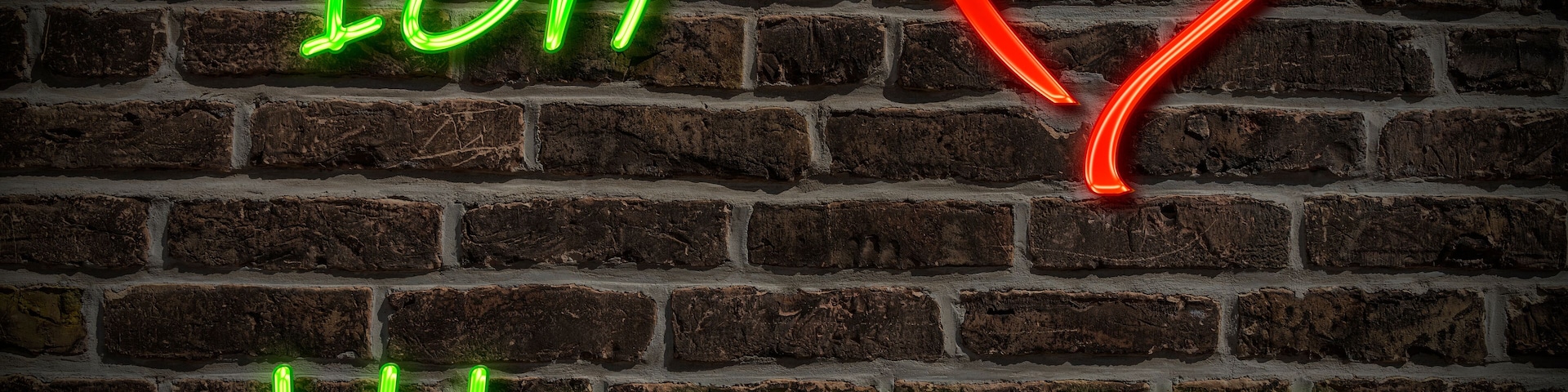 Un letrero de neón con el texto "Ich Wasungen" y una forma de corazón roja sobre una pared de ladrillo.
