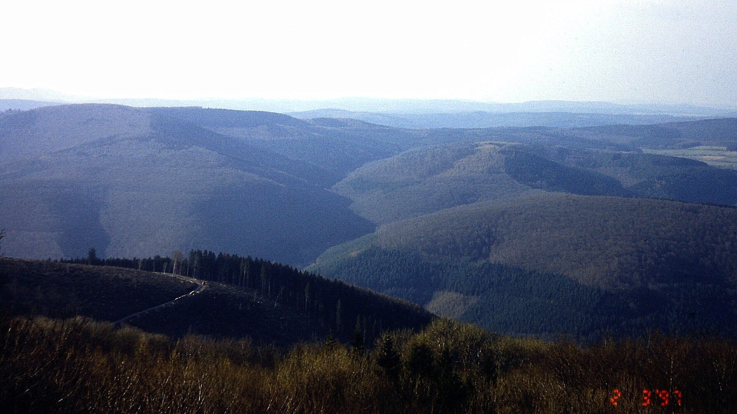 Katzenbuckel: Aussicht vom Katzenbuckelturm nach Nordwesten in den hessisch-badischen (Buntsandstein-)Odenwald; Landschaftselemente: Ittertal (vorne), Hohe Warte (bis 549 m, Mitte links), Neunkircher Höhe (bis 605 m, an Horizont ganz links); März 1997