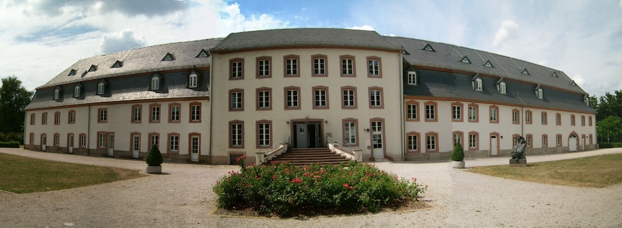 A large, historic building with a symmetrical facade, multiple windows, and a central entrance with steps.