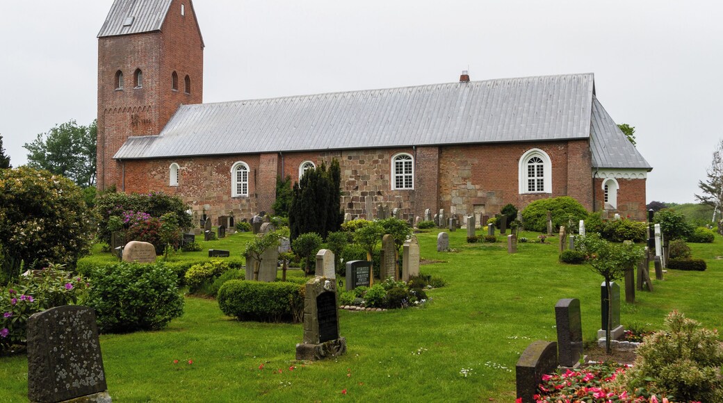 Designation: Churchyard with stone wall Location: Sarkstig House number: 1 Place: Süderende, Collective municipality Föhr-Amrum, District Nordfriesland, Schleswig-Holstein, Federal Republic of Germany Construction time: second half of the 12th century Description: St. Laurentii was first mentioned in a Church Directory from the year 1240. The building has been extended several times in the centuries of the existence. Object identification: 19364