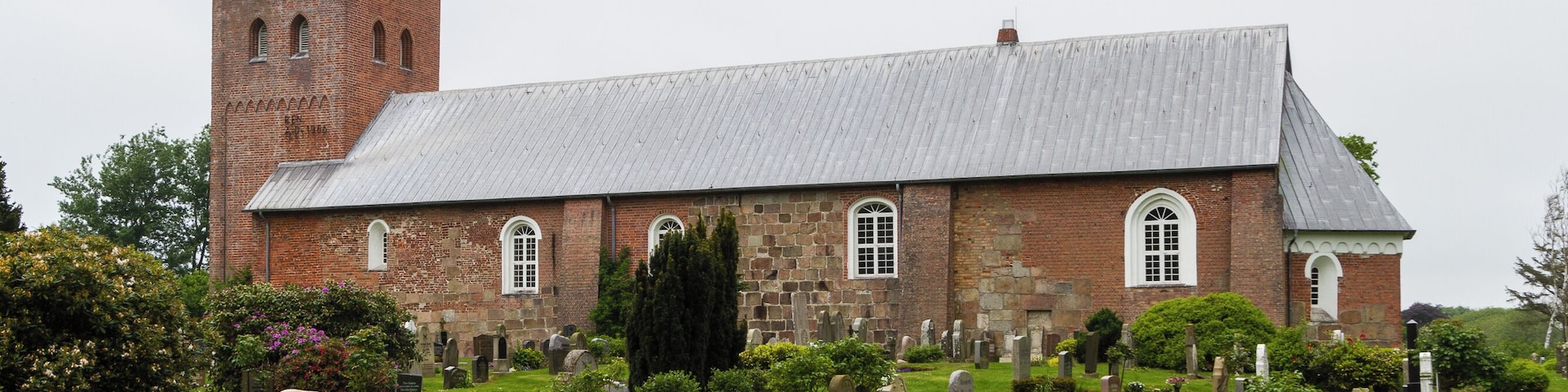 Designation: Churchyard with stone wall Location: Sarkstig House number: 1 Place: SĂŒderende, Collective municipality Föhr-Amrum, District Nordfriesland, Schleswig-Holstein, Federal Republic of Germany Construction time: second half of the 12th century Description: St. Laurentii was first mentioned in a Church Directory from the year 1240. The building has been extended several times in the centuries of the existence. Object identification: 19364
