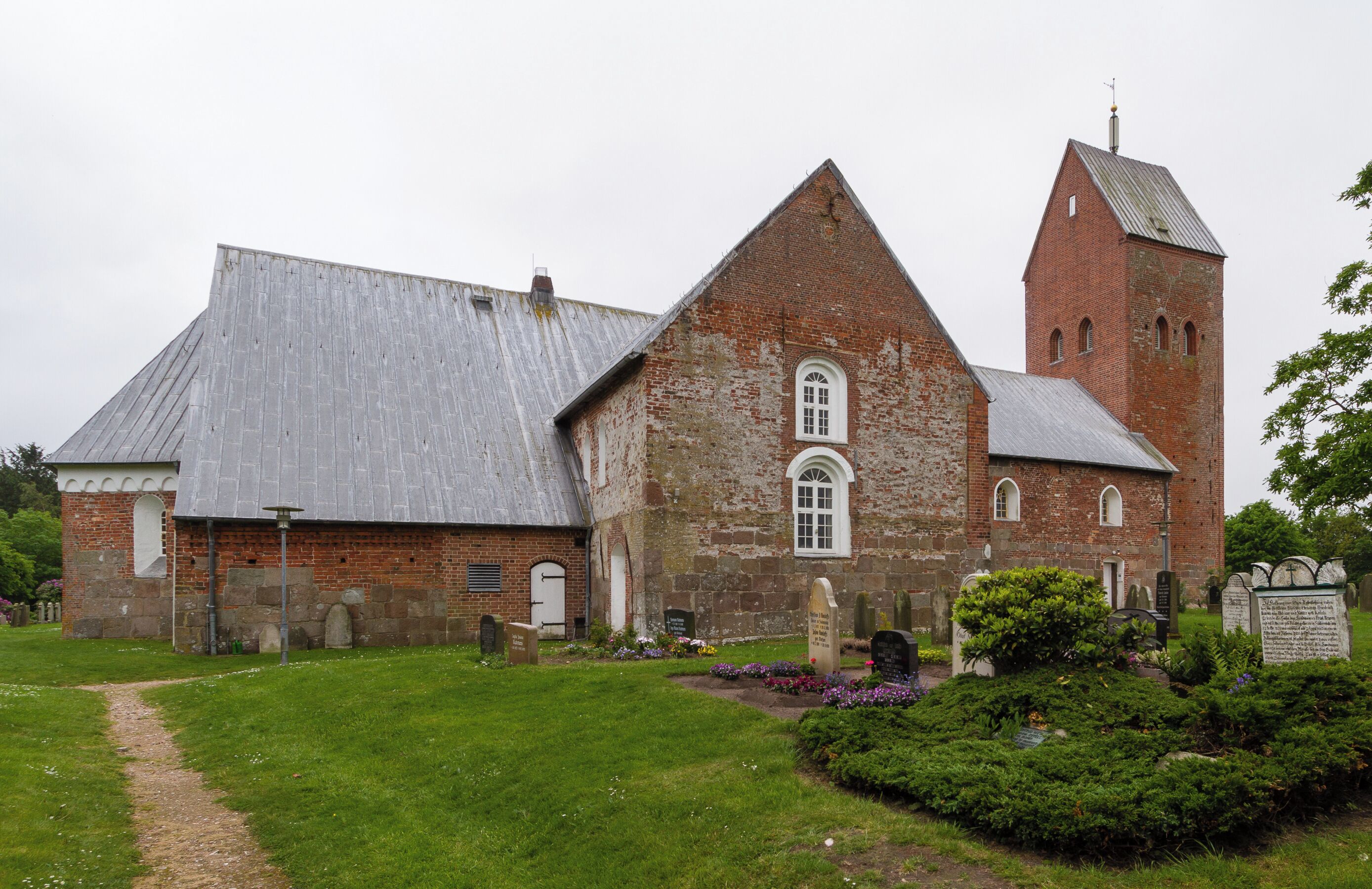 Designation: Churchyard with stone wall Location: Sarkstig House number: 1 Place: Süderende, Collective municipality Föhr-Amrum, District Nordfriesland, Schleswig-Holstein, Federal Republic of Germany Construction time: second half of the 12th century Description: St. Laurentii was first mentioned in a Church Directory from the year 1240. The building has been extended several times in the centuries of the existence. Object identification: 19364