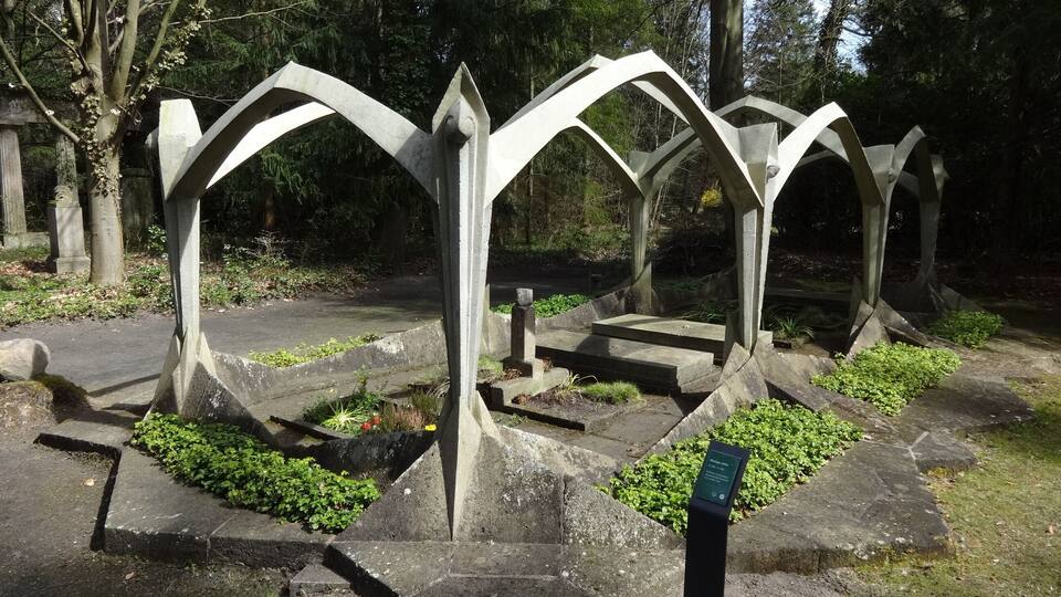 A metal sculpture with arches in a park.