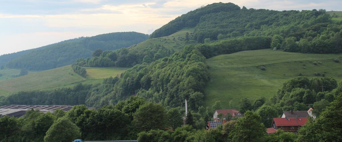 Blick ĂŒber HĂ€user von Abstroda und Teile des Palettenwerks Krenzer nordwestwĂ€rts zur Weiherkuppe