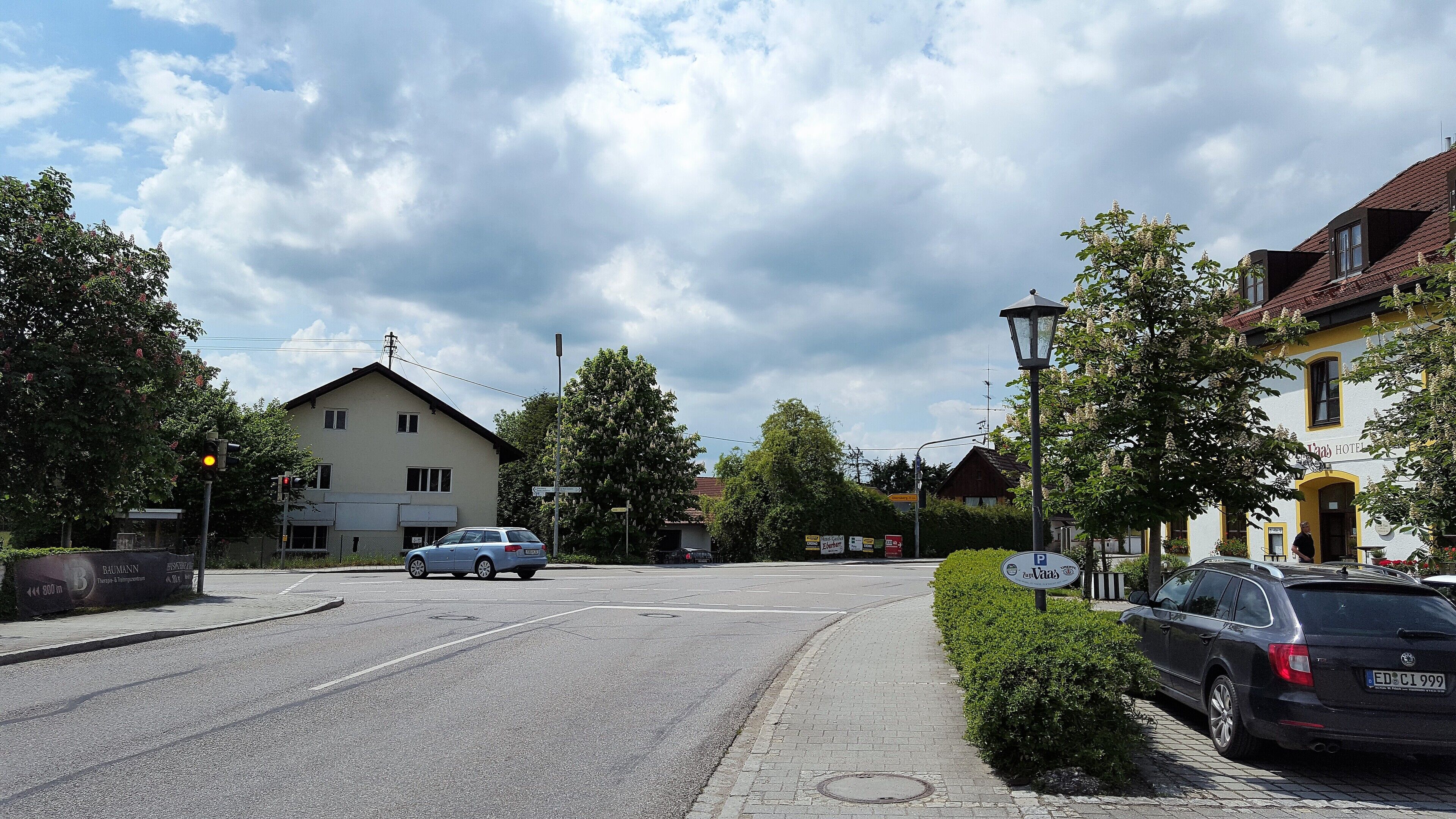 A street with cars, a building labeled "Baumann," and a hotel named "Thaa Hotel."