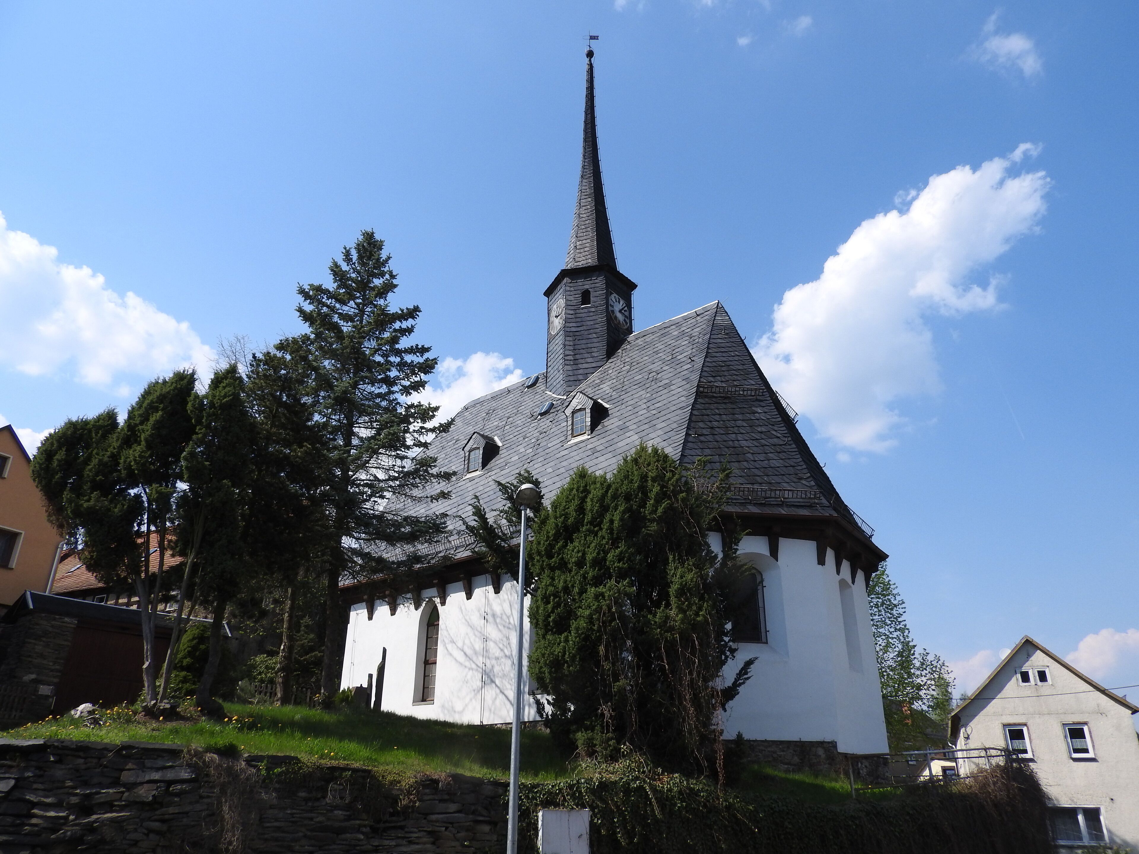 A church with a tall steeple and a clock tower.