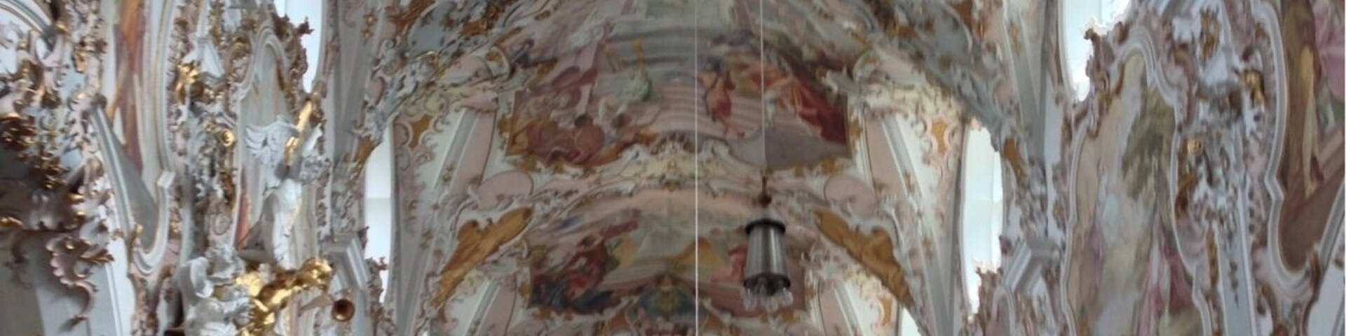 An ornate church interior with elaborate frescoes and gold accents.