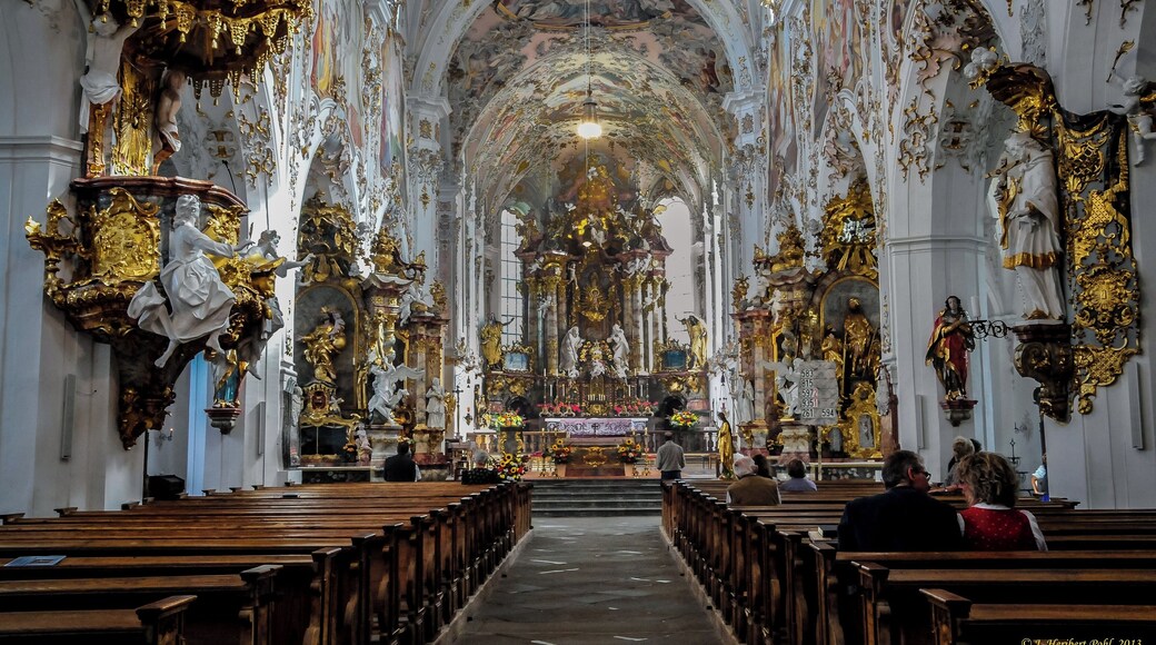 Um 1085, zur Zeit der Klostergründung durch Herzog Welf I wurde bereits eine romanische, dreischiffige Basilika mit Querschiff und Flachdach errichtet. Mitte des 15 Jhd wurde die Kirche durch den Baumeister Hansen erstmals umgebaut. Heute ist die Kirche eine dreischiffige Basilika, mit freistehenden Glockenturm und romanischen Grundriss. Die architektonischen Proportionen sind Gotisch. Im Innenraum verschmelzen die Stilrichtungen des Rokoko, der Gotik und der Romantik. Sie ist eine der schönsten Kirchen Deutschlands und ein Juwel des Allgäuer Pfaffenwinkels Around 1085, the time of the founding of the monastery by Duke Welf I, a Romanesque three-nave basilica was built with transept and flat roof. Middle of the 15th century the church was rebuilt for the first time by the builder Hansen. Today the church is a basilica, with free-standing bell tower and Romanesque ground plan. The architectural proportions are Gothic. In the interior fuse the styles of the Rococo, Gothic and Romance. It is one of the most beautiful churches in Germany and a jewel of the allgaeur Pfaffenwinkel.