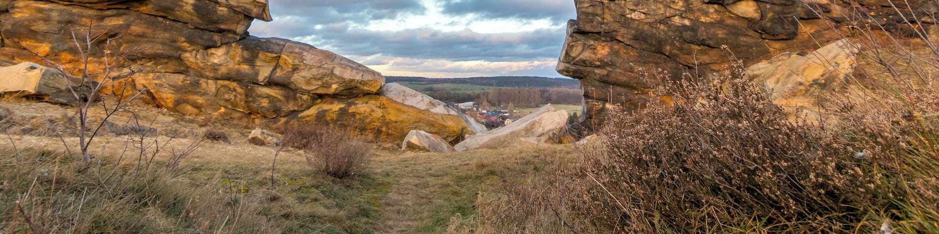 A rocky landscape with prominent rock formations and a distant view of a town.