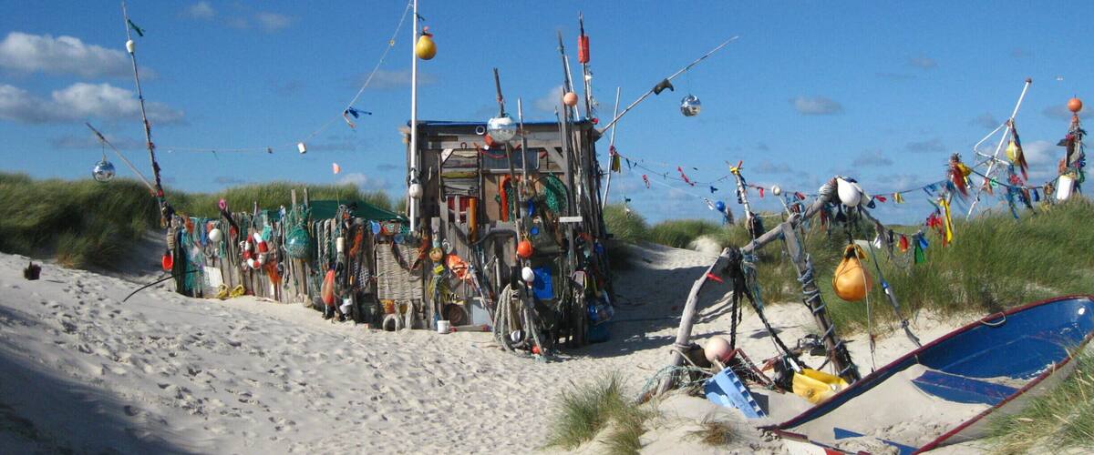 A beach with a makeshift structure made of various objects and materials.