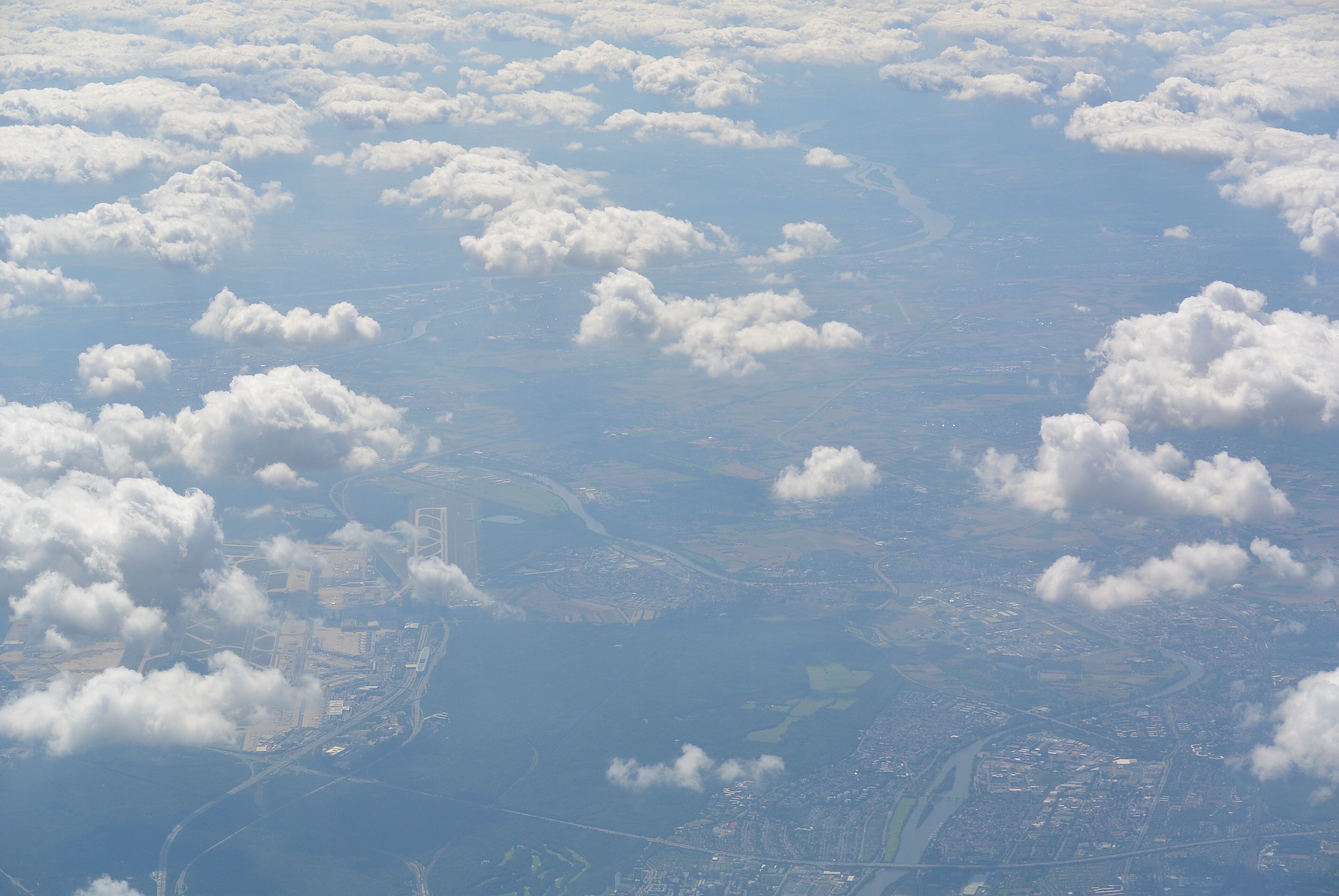 A cityscape with scattered clouds above.