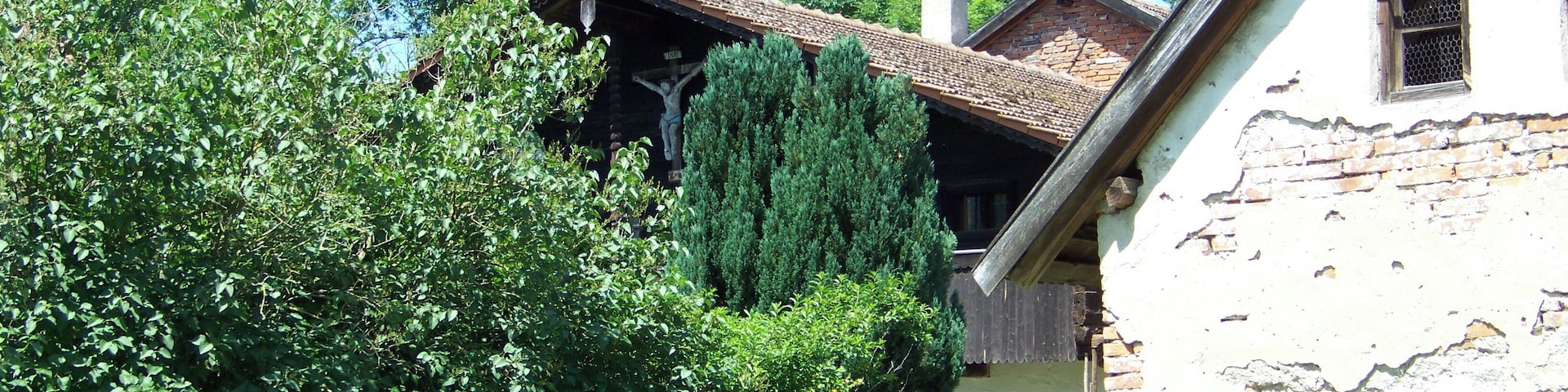 Metten, Zeitldorf 6. Wohnstallhaus. Erdgeschossiger Flachsatteldachbau mit hohem Blockbau-Kniestock, Giebelschrot, geschnitzten Schrotsäulen und Giebelkruzifix, Ende 18. Jahrhundert.