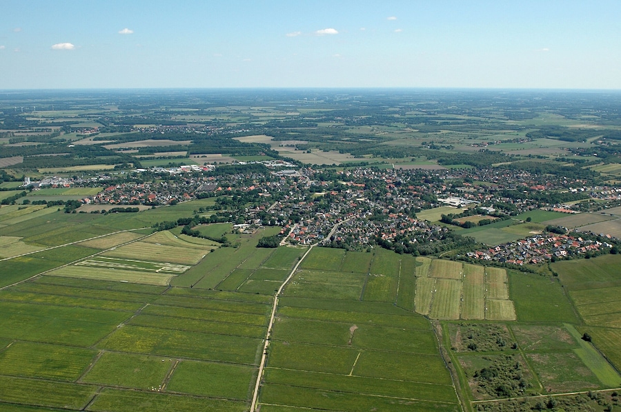 Eine Vogelperspektive auf eine ländliche Stadt, umgeben von Feldern und Ackerland.