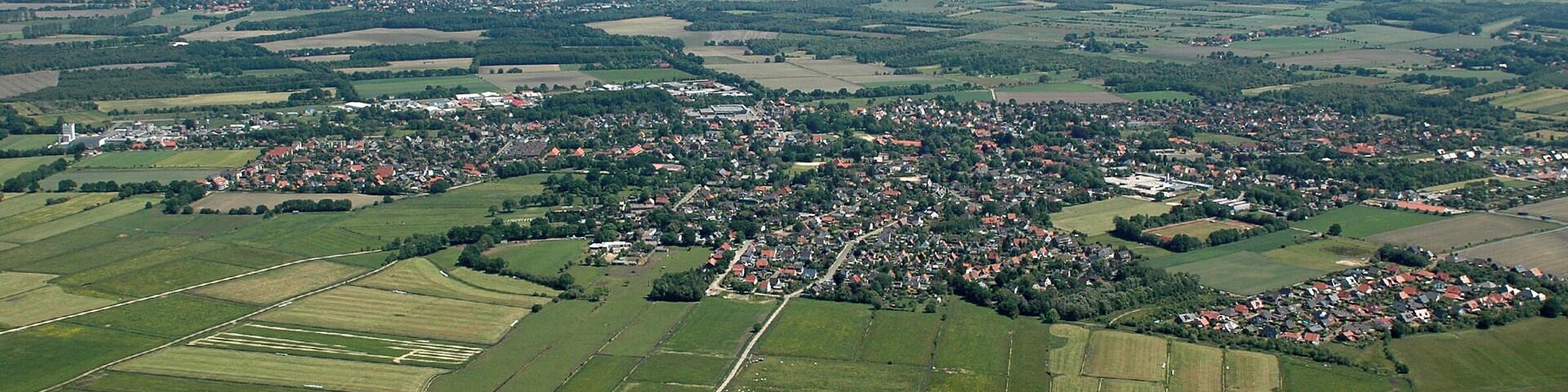An aerial view of a rural town surrounded by fields and farmland.