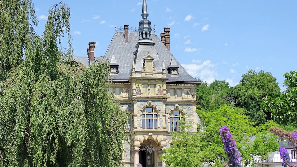 A large, historic building with a prominent tower and ornate architecture.