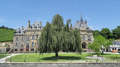 Un edifici gran i històric amb diverses torres i un jardí ben cuidat.
