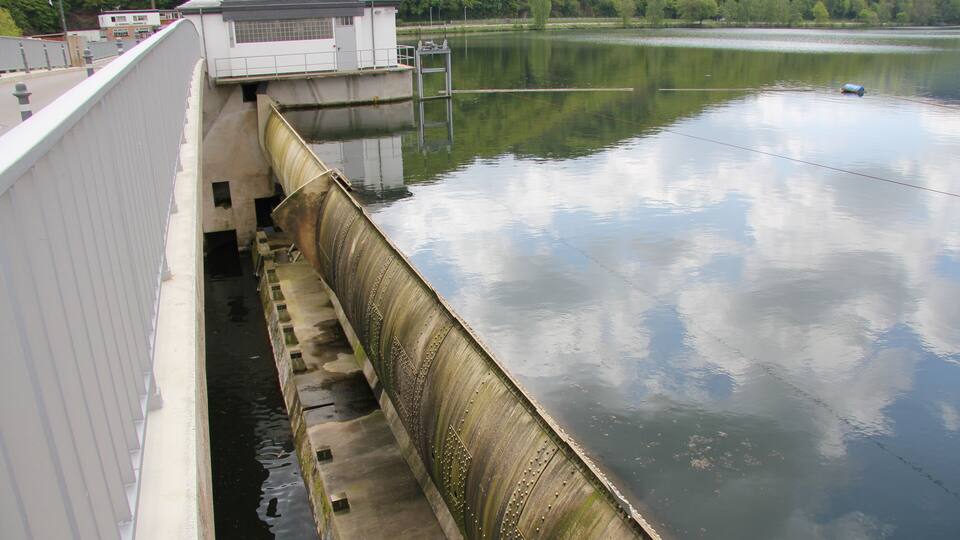 A dam with a water spillway and a control building.