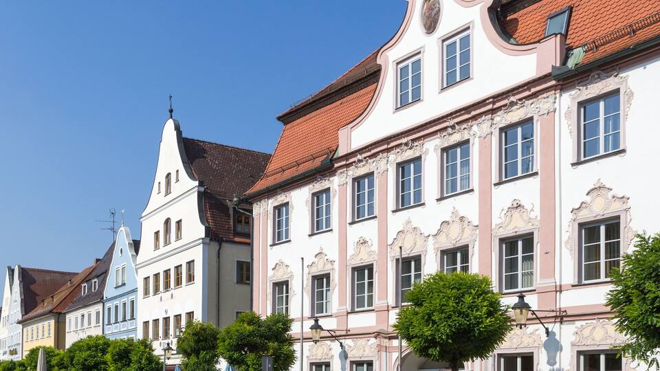 A row of historic buildings with ornate facades and red-tiled roofs.