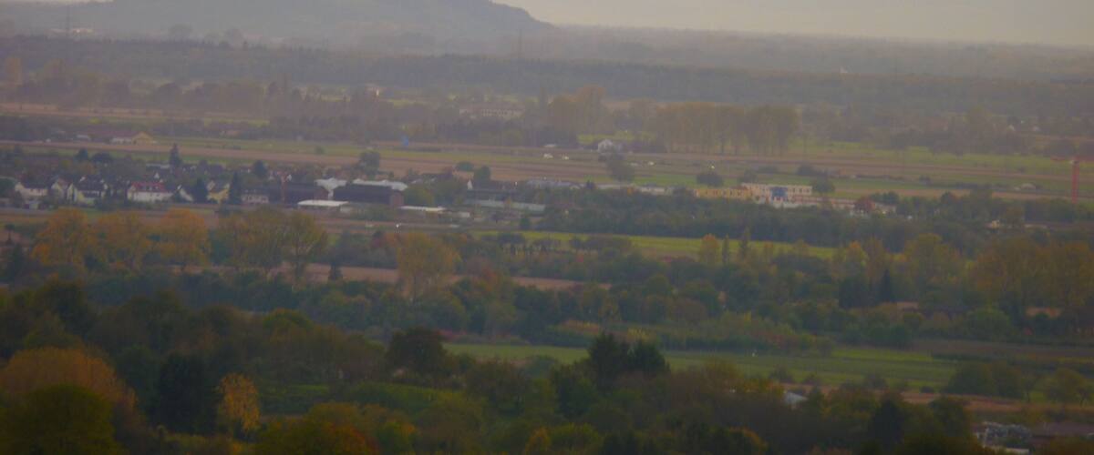 A rural landscape with rolling hills and scattered houses.