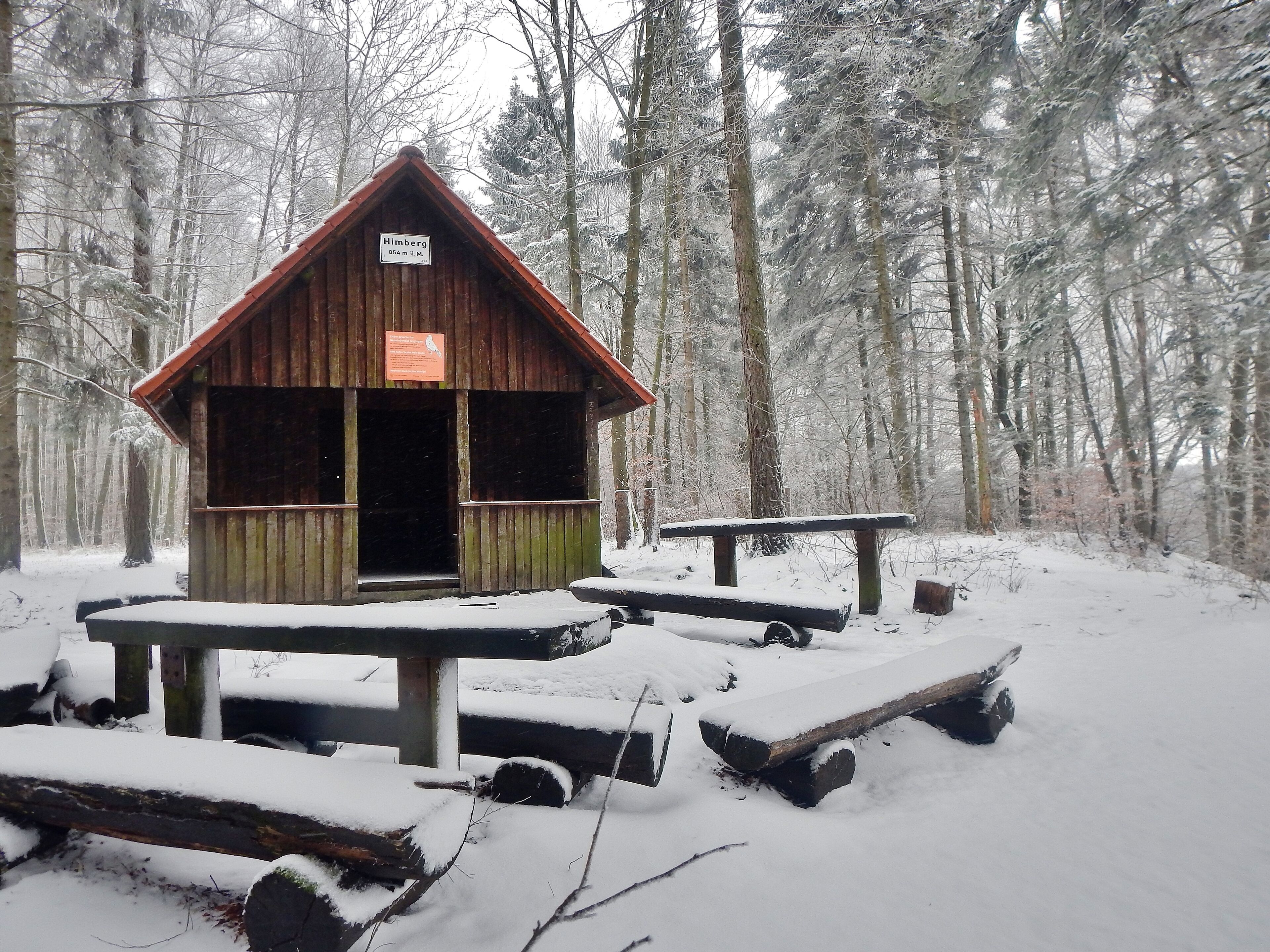 A wooden cabin named 'Himberg' in a snowy forest.