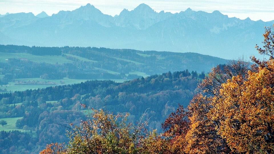 A mountainous landscape with autumn foliage and distant peaks.