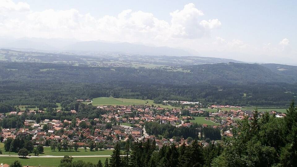 A town nestled in a valley with surrounding hills and forests.