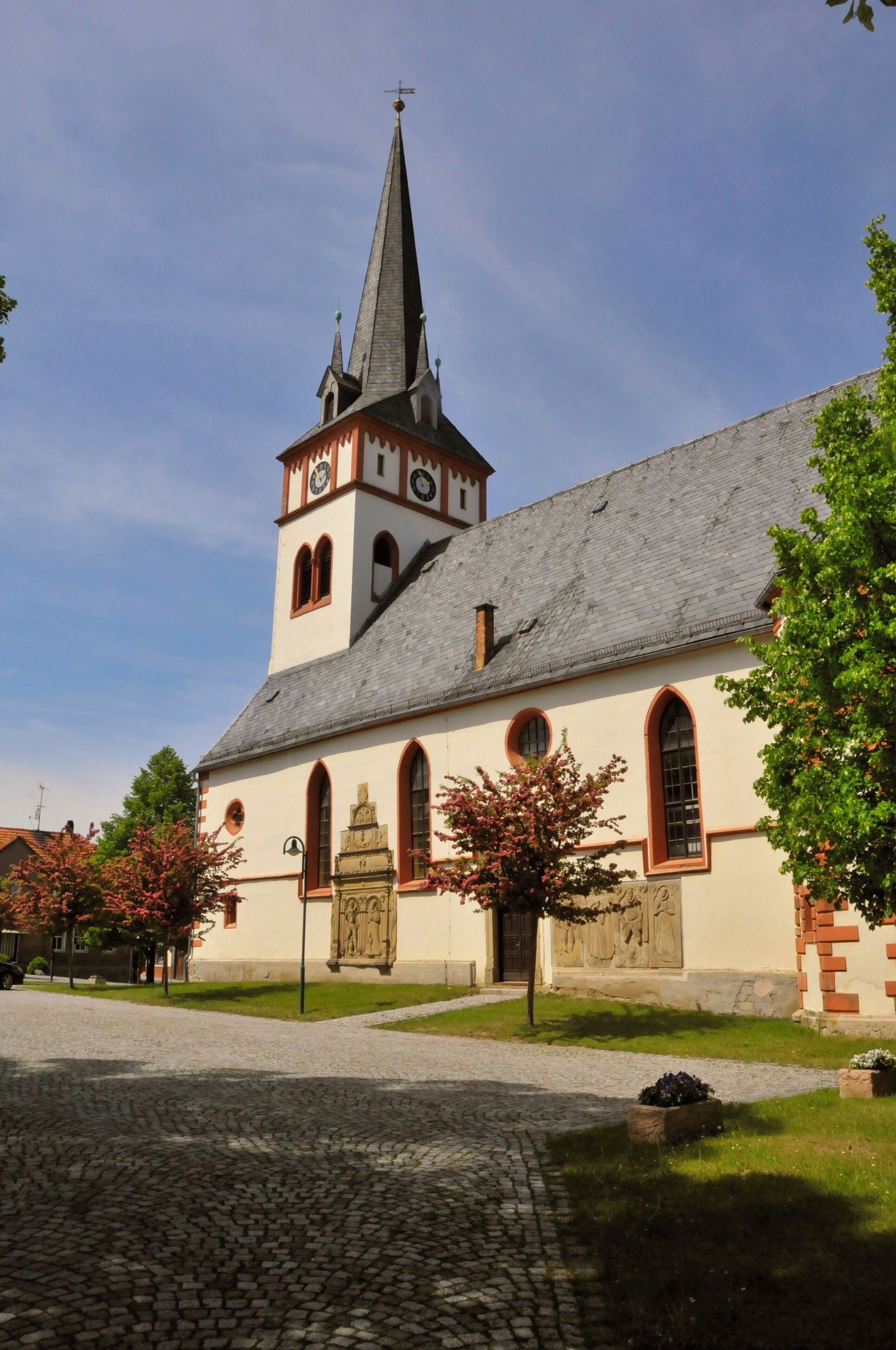 A church with a tall steeple and a clock tower.
