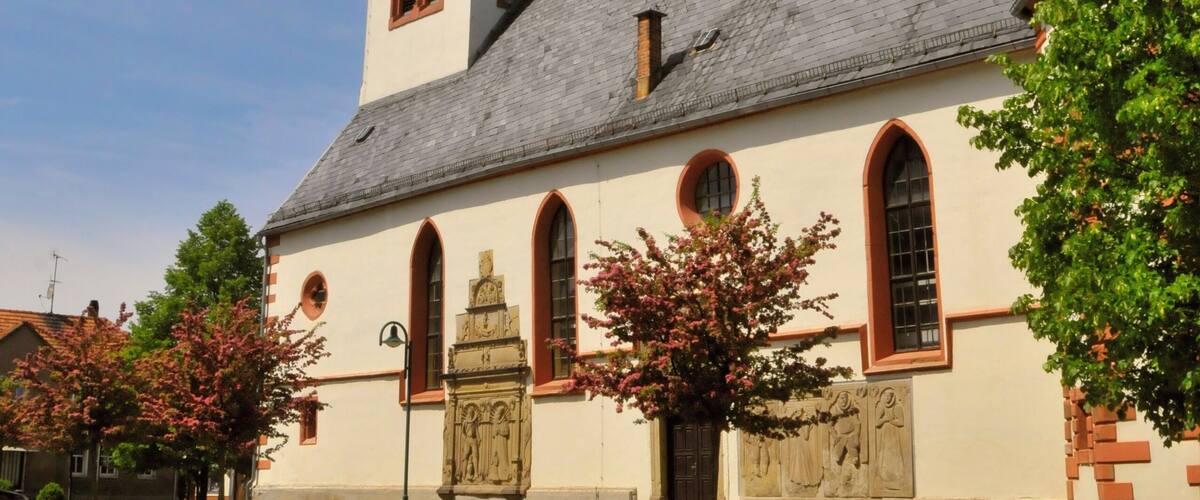 A church with a tall steeple and a clock tower.