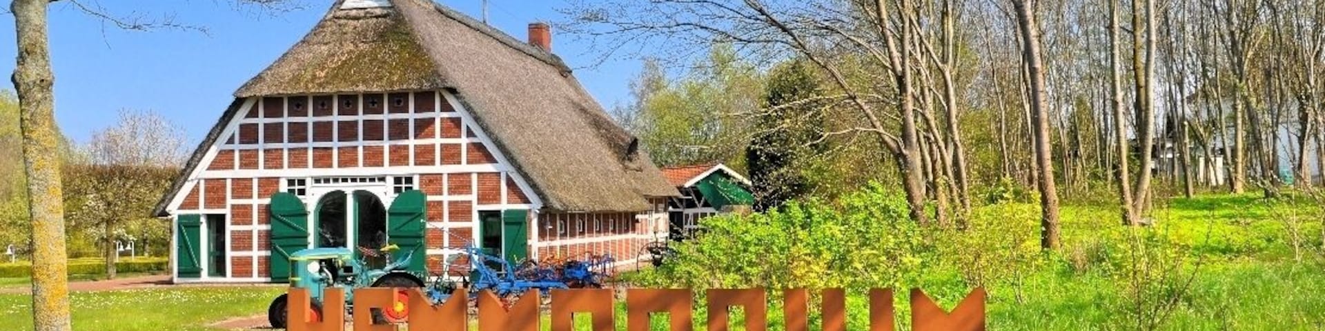 Una casa tradicional con techo de paja y un letrero que dice "HENEMODRIUM".
