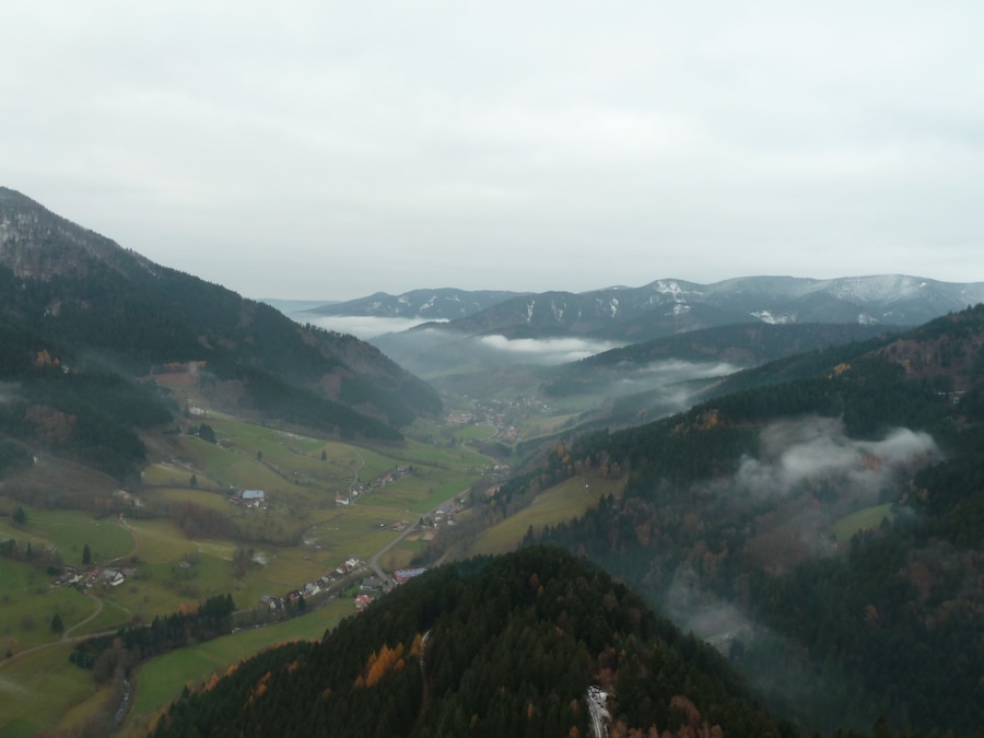 A valley with a river, surrounded by mountains and covered in mist.