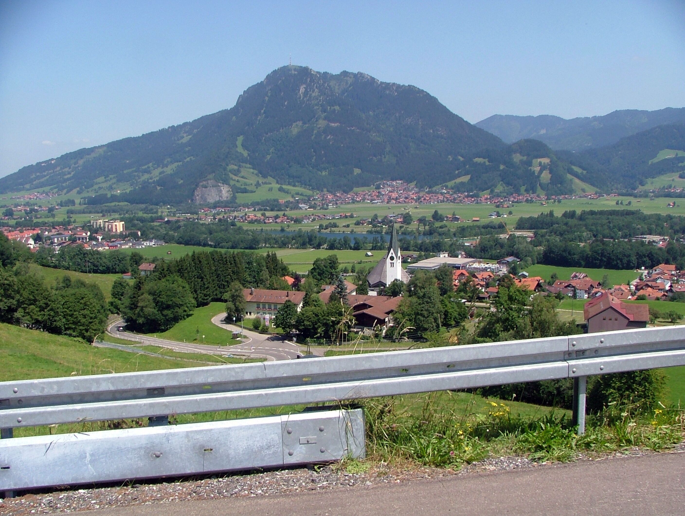 A mountainous landscape with a town, a church, and a road.