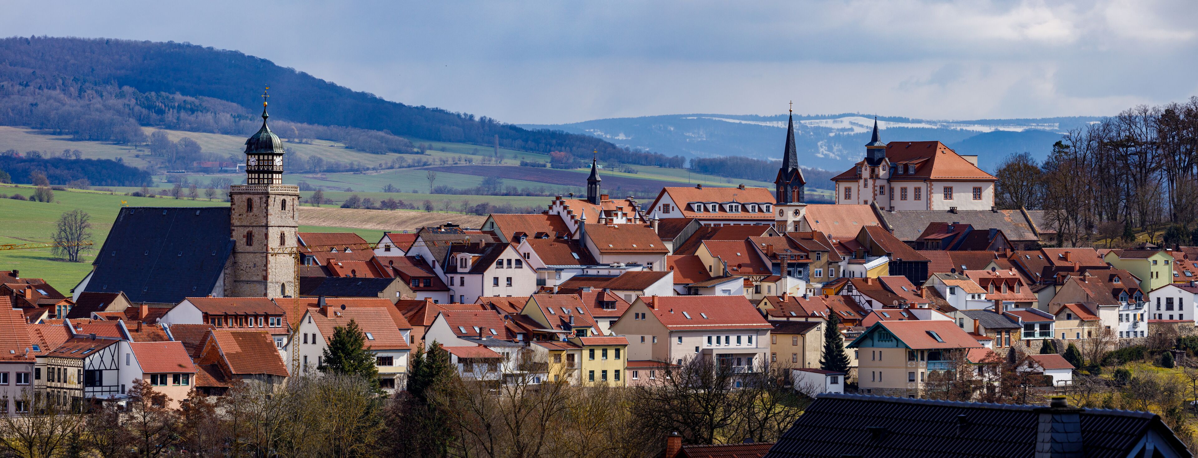 A town with red-roofed houses, a church, and a tower.