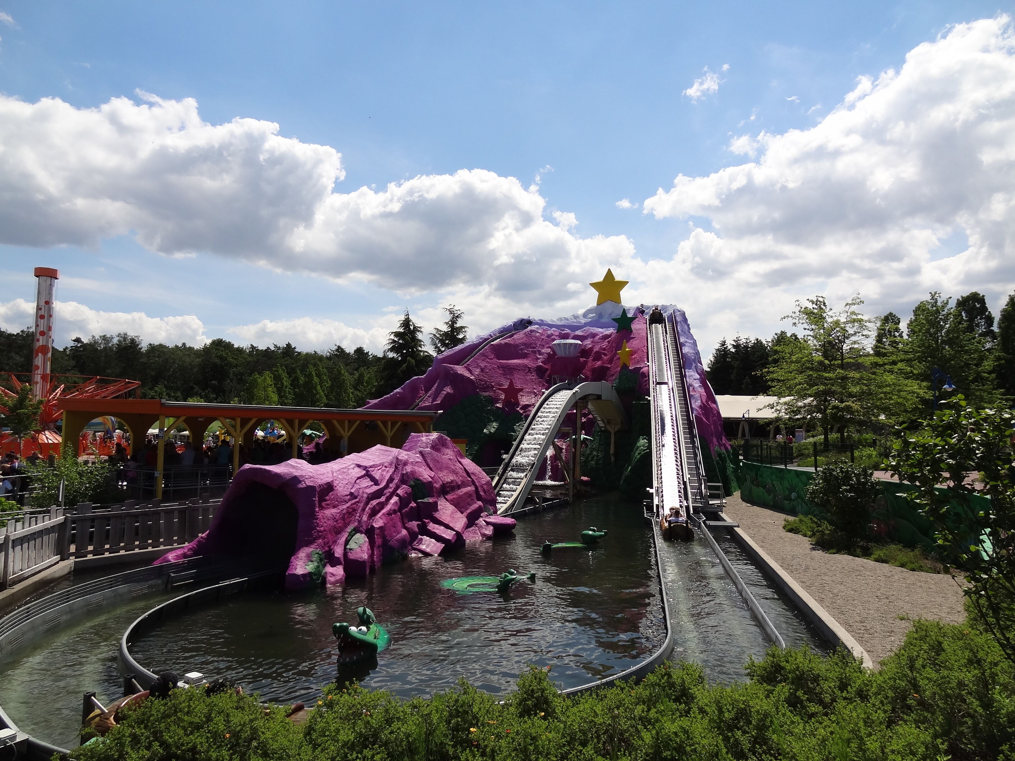 A water park with a purple mountain, slides, and a star on top.