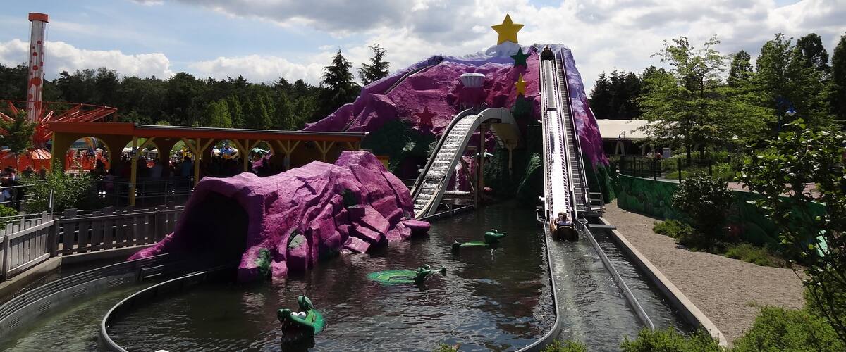 A water park with a purple mountain, slides, and a star on top.