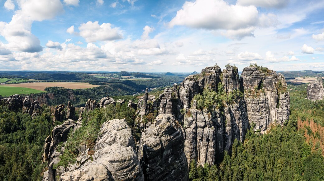 wide panorama of schrammsteine rock-formation in saxon switzerland, elbe sandstone highlands, germany with blue sky