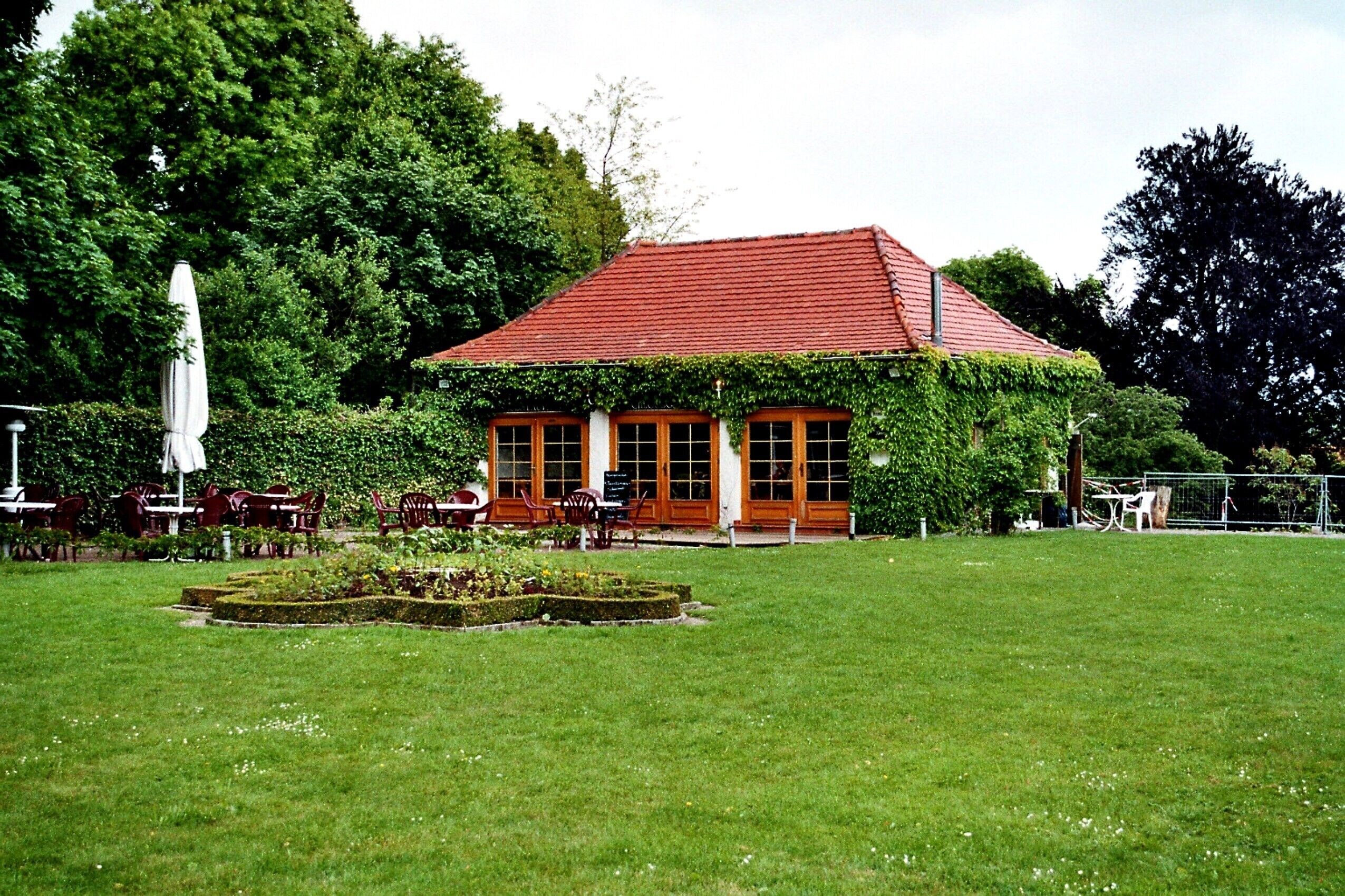 A red-roofed building with a garden in front.