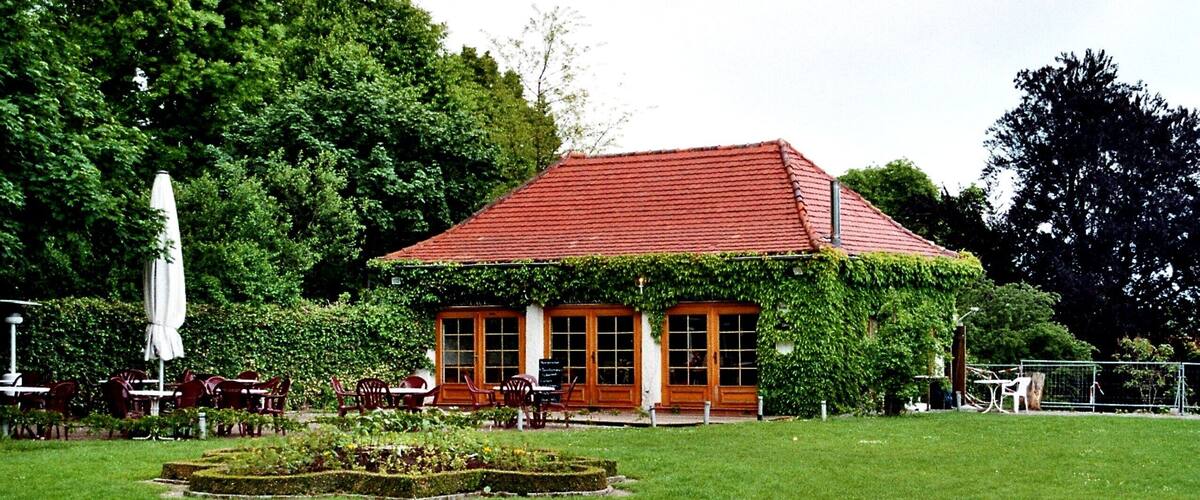 A red-roofed building with a garden in front.