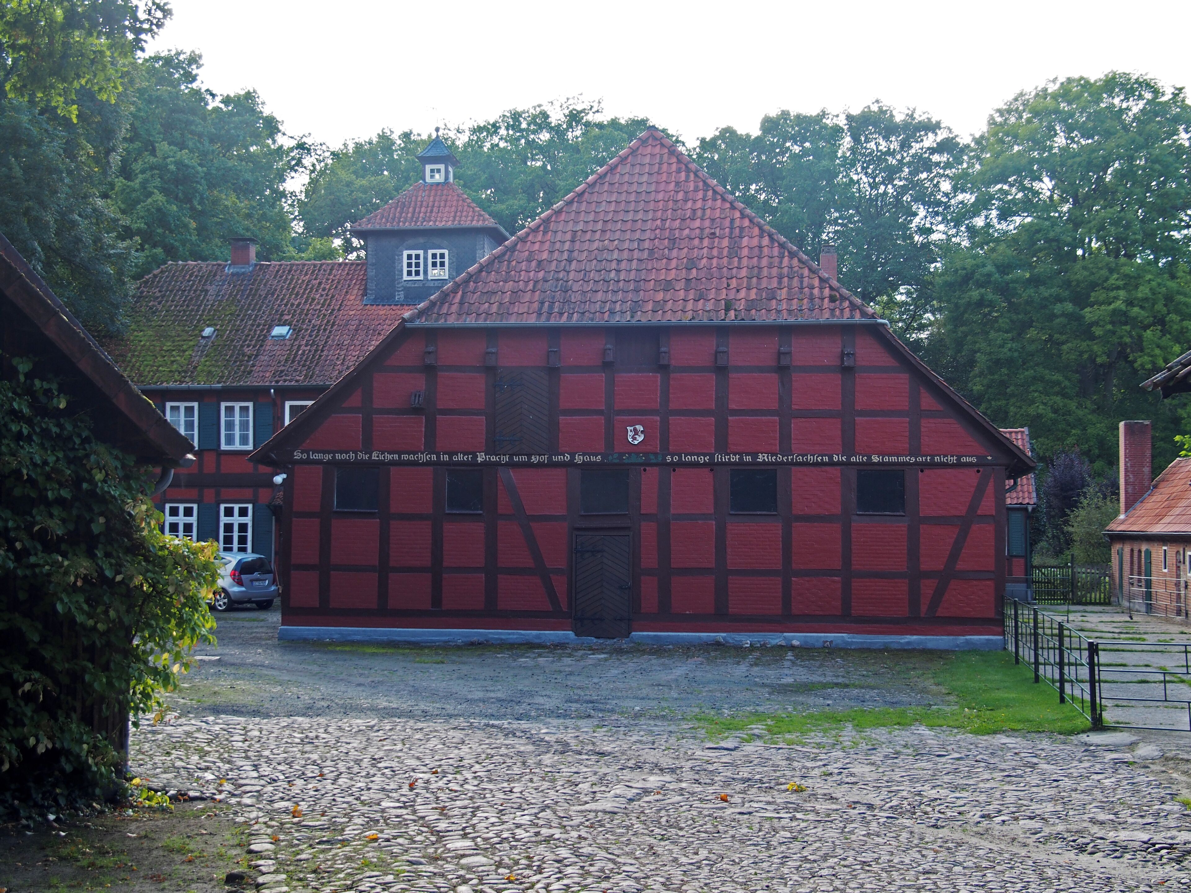 A traditional half-timbered house with a red roof and a small tower.