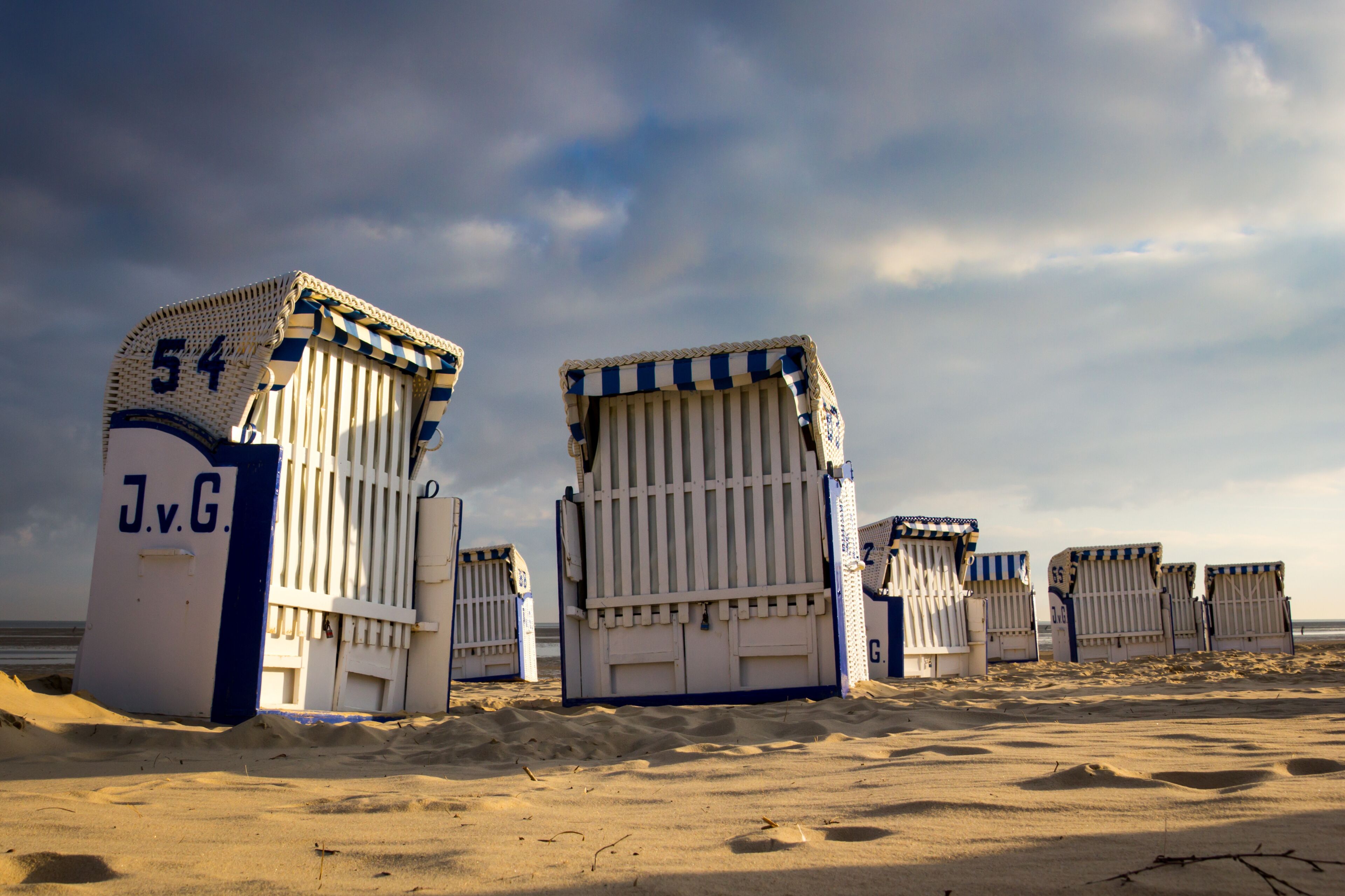 Beach huts with striped awnings and numbers on them.