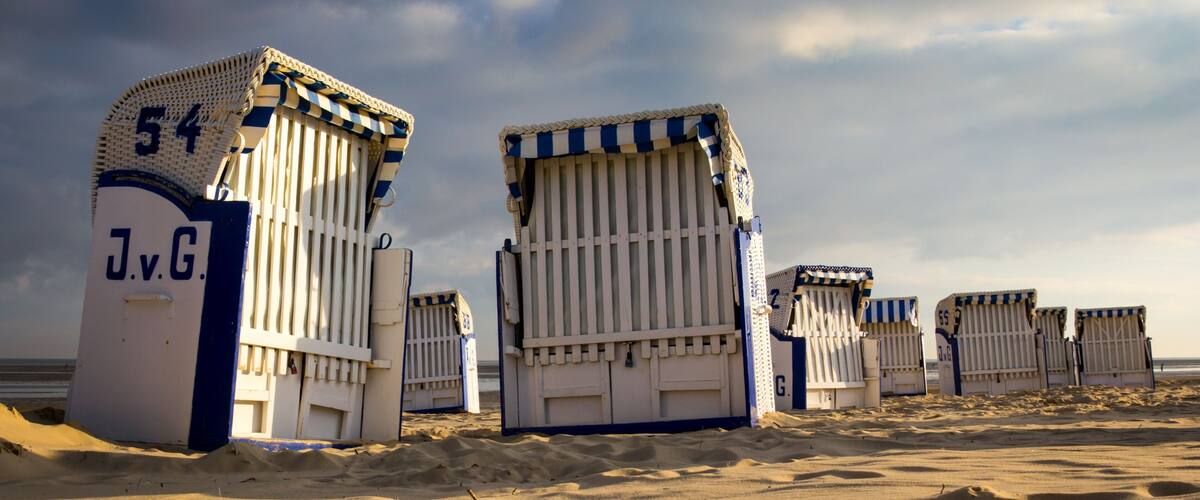 Beach huts with striped awnings and numbers on them.