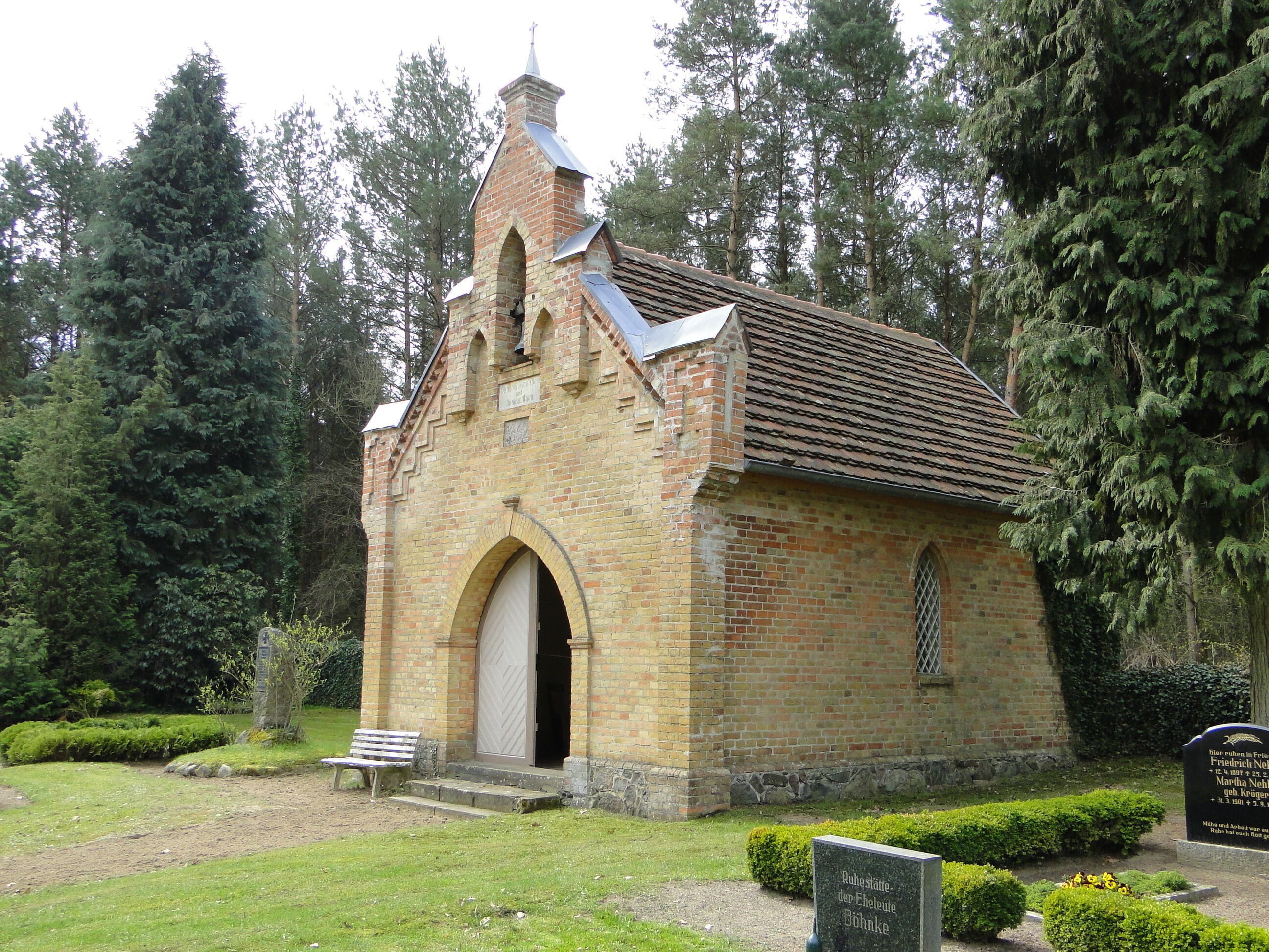 A small brick church with a pointed roof and an arched entrance.