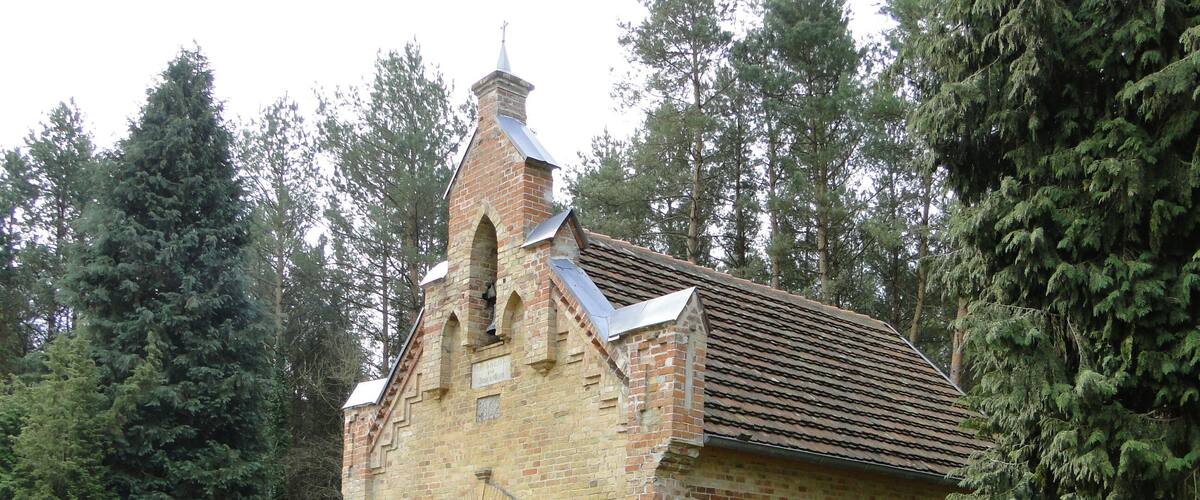 A small brick church with a pointed roof and an arched entrance.